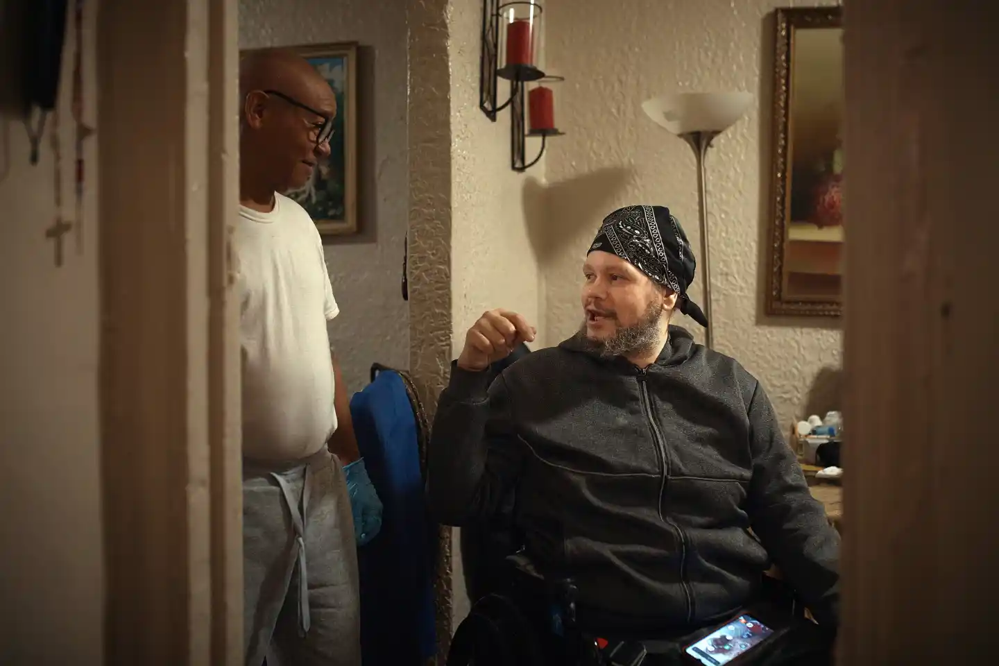 Two residents speaking inside a Bronx apartment